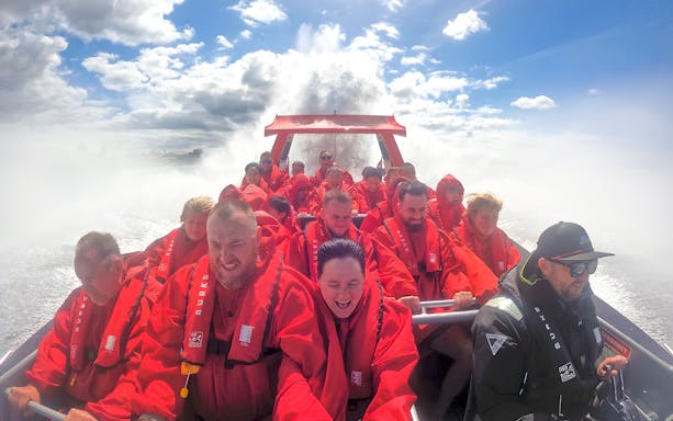 Group enjoying OZ Jet Boating ride in Sydney, water splashing around.
