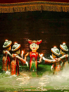 Water puppets holding candles on a misty stage at Thang Long Water Puppet Theatre, Hanoi.