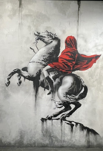Banksy artwork of a hooded figure on a rearing horse at Amsterdam museum.