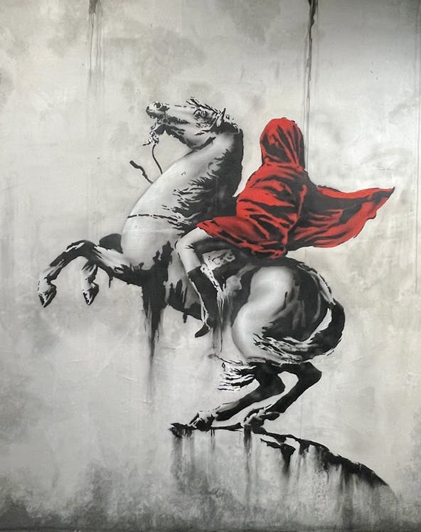 Banksy artwork of a hooded figure on a rearing horse at Amsterdam museum.