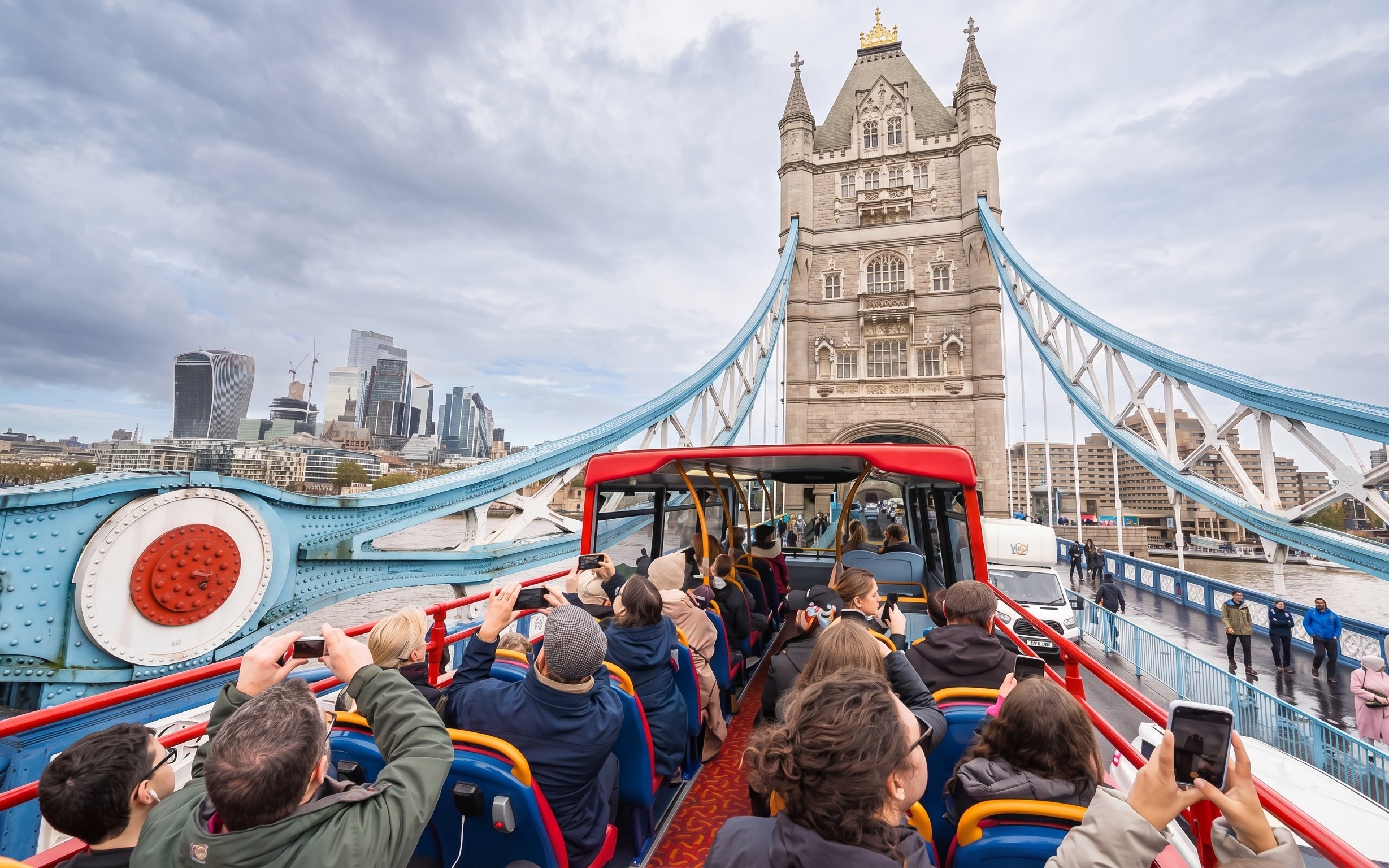 Open-top bus tour crossing Tower Bridge in London.
