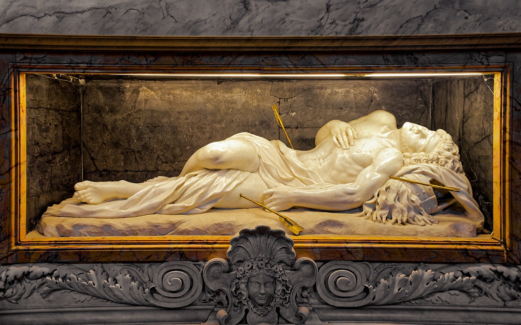 Marble sculpture of a reclining figure with arrows, St. Peter’s Basilica tour.