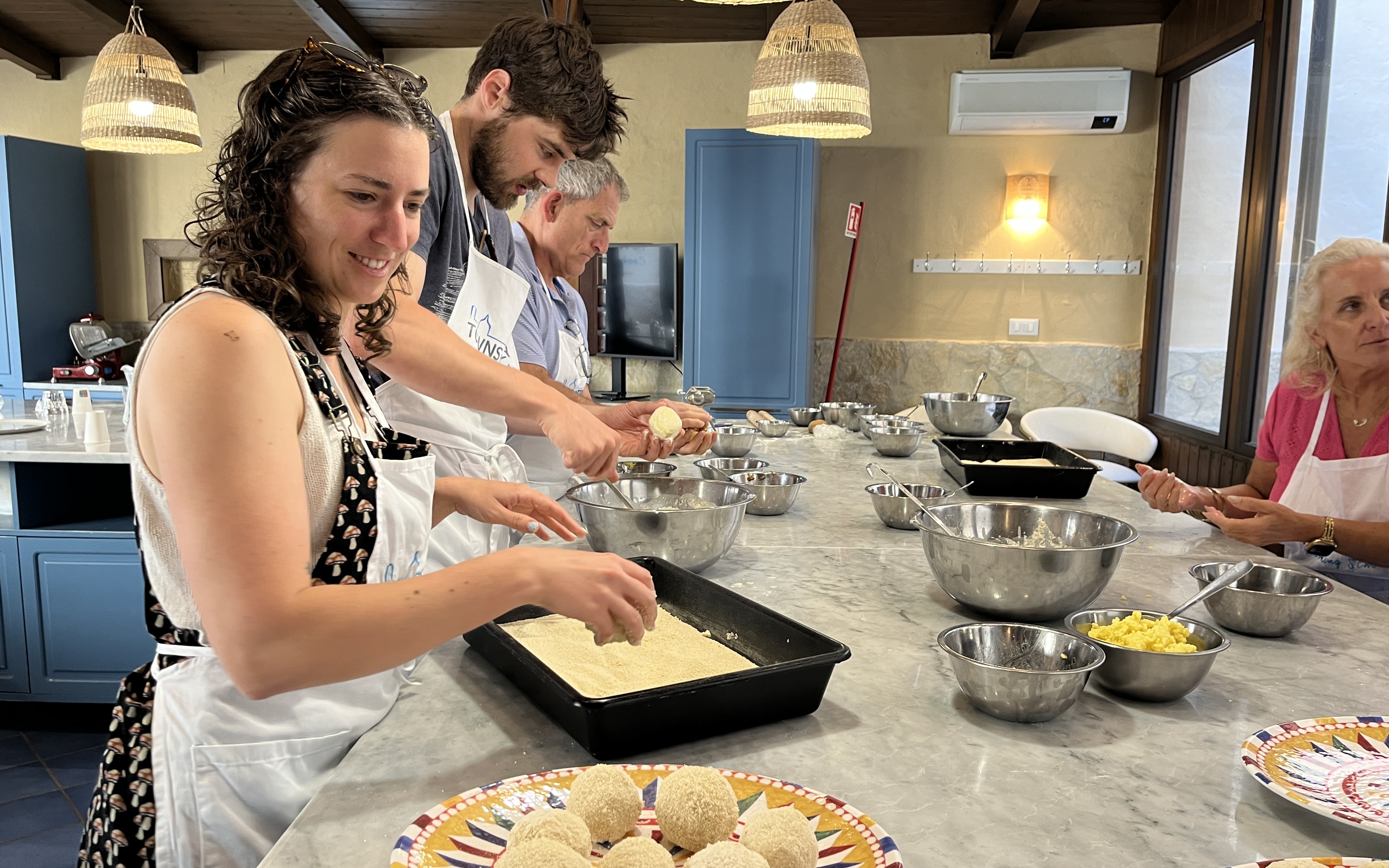 Cooking class participants preparing arancini at a Palermo market tour.