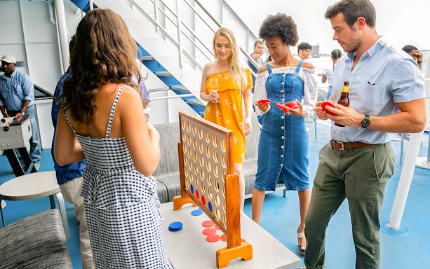 Guests playing a game on the deck during New York Signature Dinner Cruise.