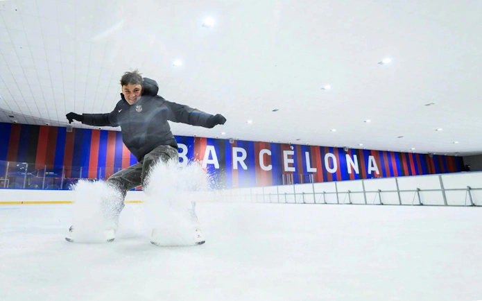 Ice skater performing at FC Barcelona Ice Rink with Barcelona signage in the background.
