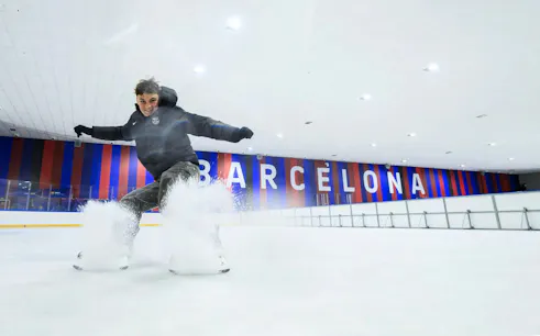Ice skater performing at FC Barcelona Ice Rink with Barcelona signage in the background.