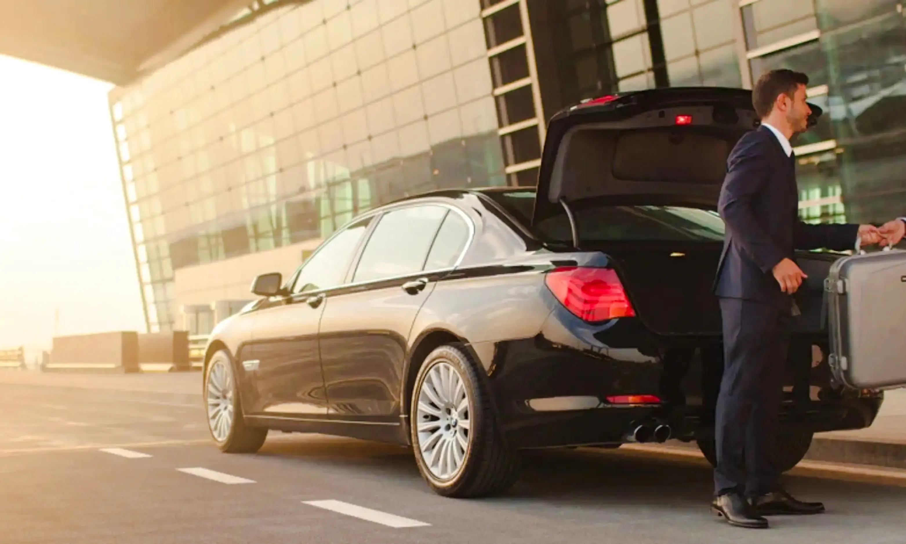 Private car transfer at AlUla airport with driver handling luggage, Medina.