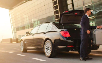 Private car transfer at AlUla airport with driver handling luggage, Medina.