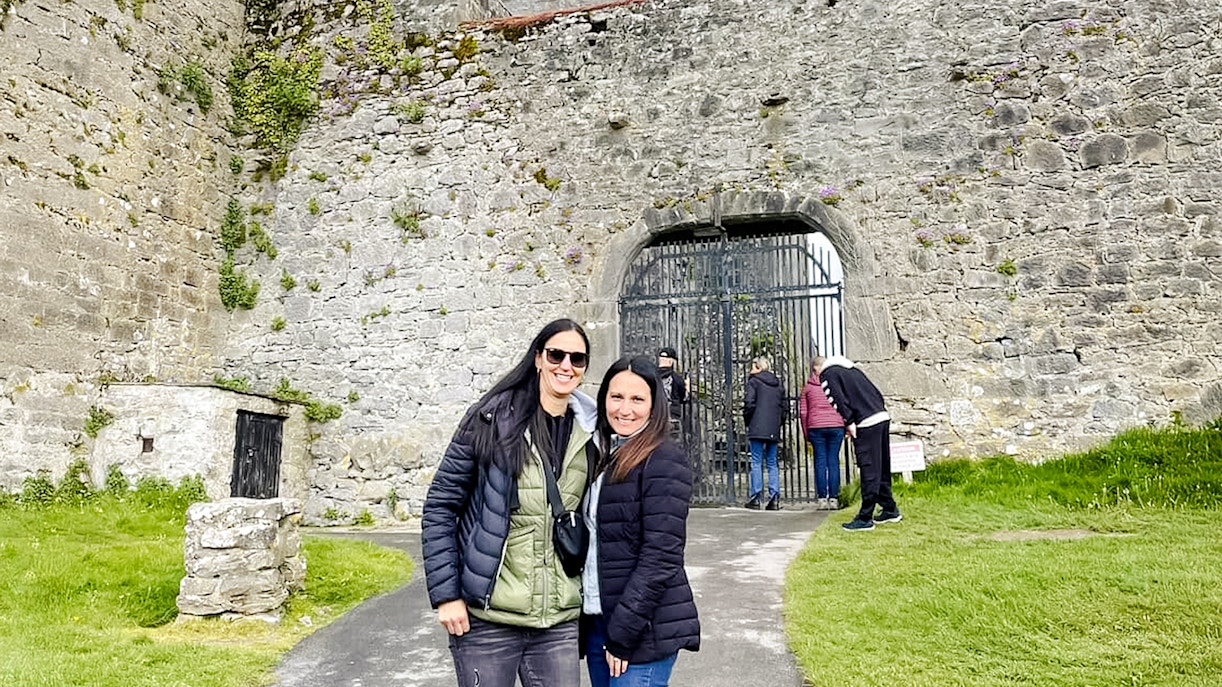 Visitors exploring the entrance of Dunguaire Castle in Ireland.