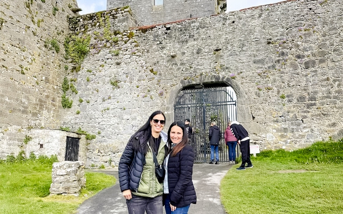 Visitors exploring the entrance of Dunguaire Castle in Ireland.