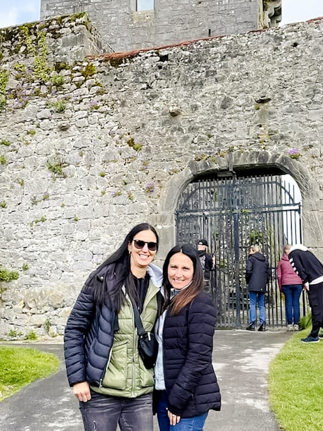 Visitors exploring the entrance of Dunguaire Castle in Ireland.