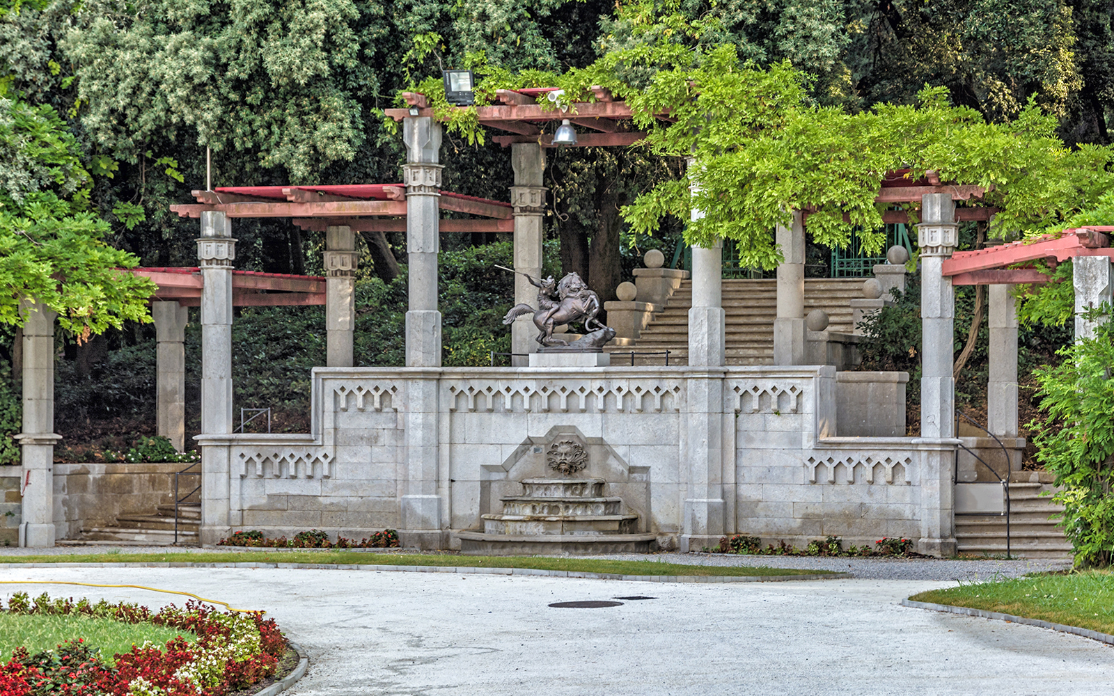 Fountain and sculptures in the garden of Miramare Castle, surrounded by greenery.