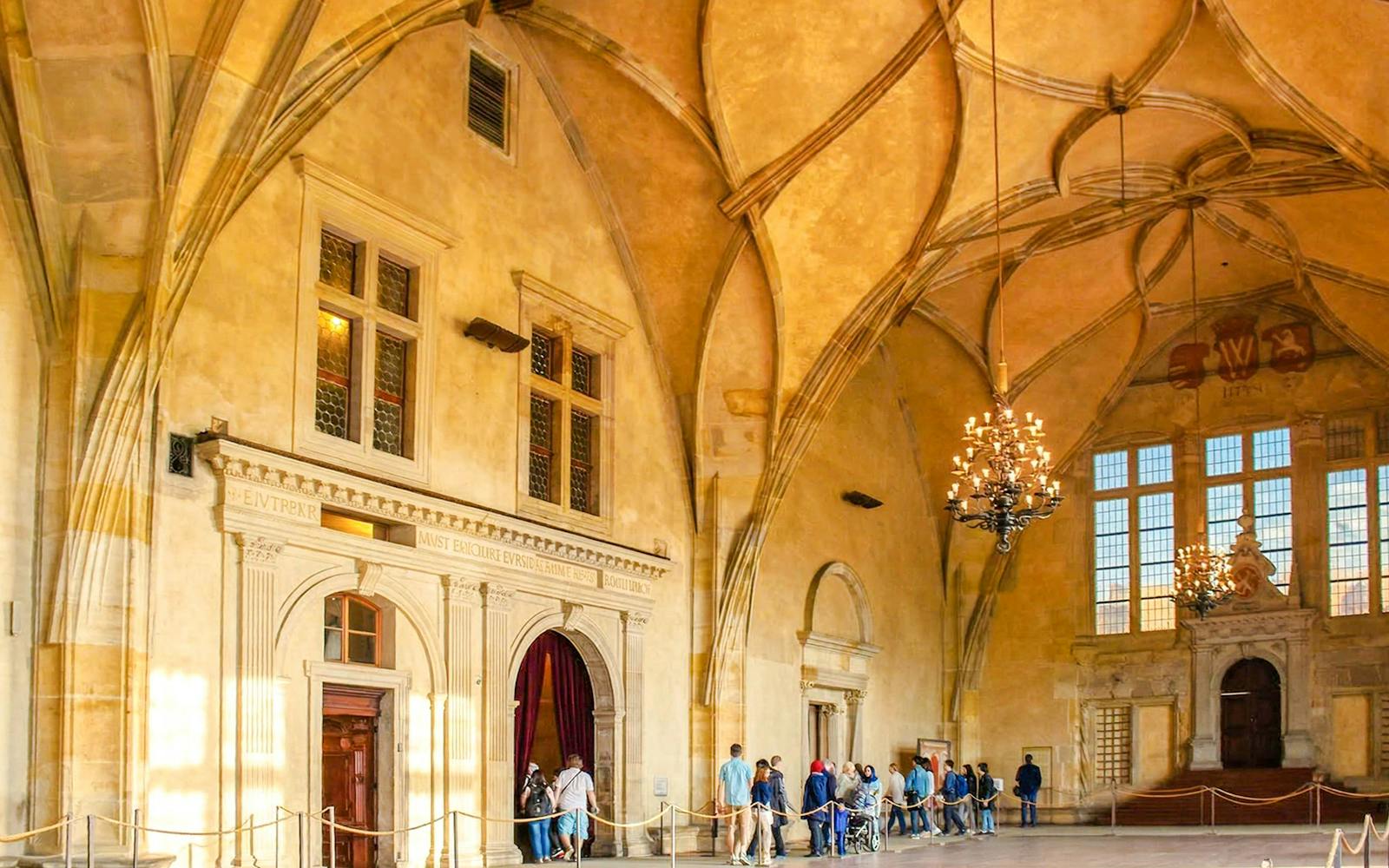 Visitors touring the historic Vladislav Hall inside Prague Castle.