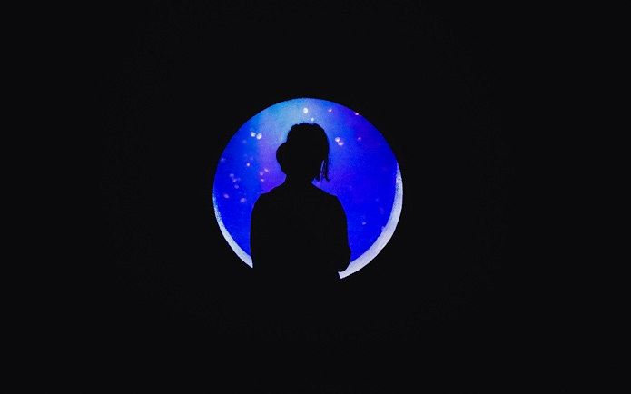 Silhouette of a person in front of a glowing aquarium tank at Jakarta Aquarium Safari.