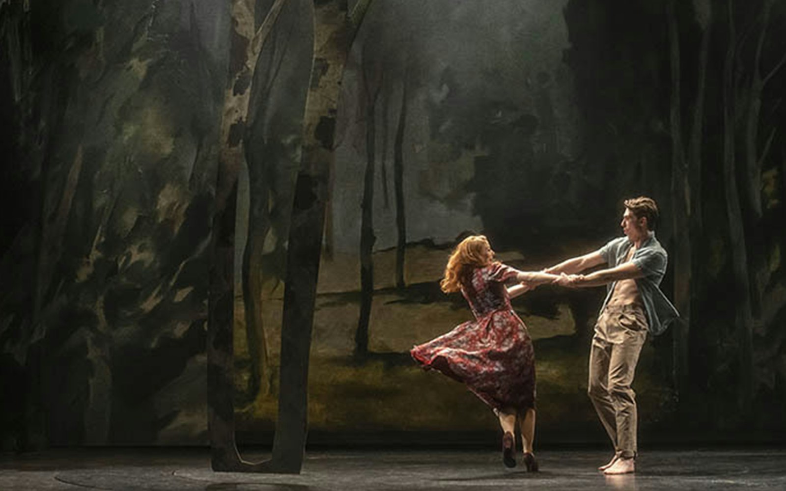 Dancers performing in a forest-themed set for "Aspects of Love" show.