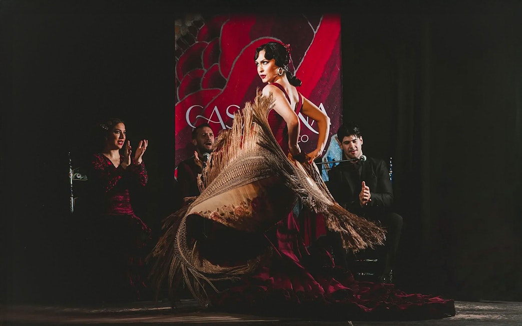 Flamenco dancer performing at Casa Ana Flamenco Show with musicians in the background.