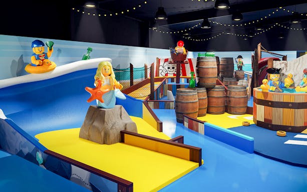 LEGOLAND Windsor Resort indoor adventure golf course with LEGO pirate and mermaid figures.