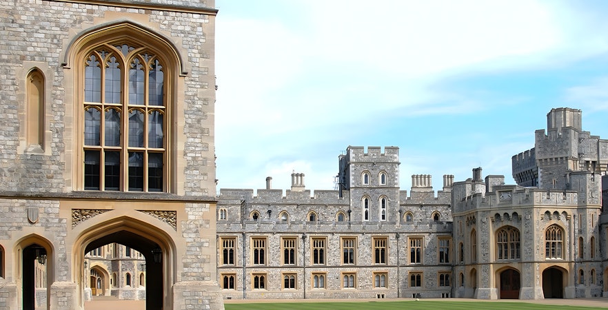 Windsor Castle Grounds with historic stone architecture and green lawn.