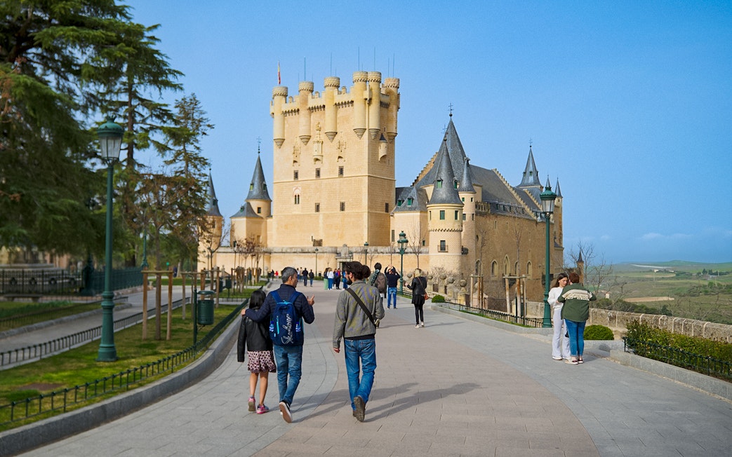 Visitors walking with a guide at Segovia Alcazar, Spain.