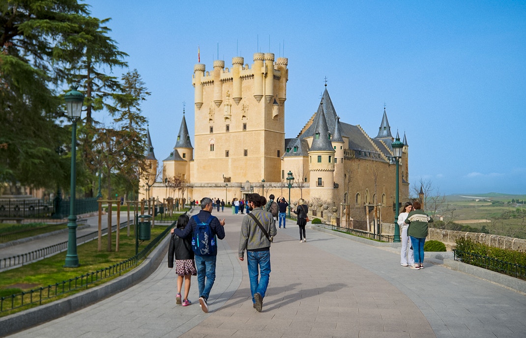 Visitors walking with a guide at Segovia Alcazar, Spain.