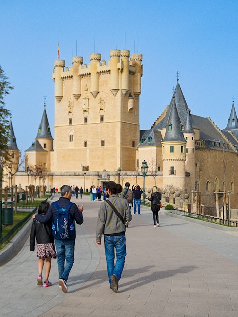 Visitors walking with a guide at Segovia Alcazar, Spain.