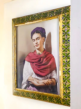 Frida Kahlo portrait in ornate frame at Frida Kahlo Museum, Mexico City.