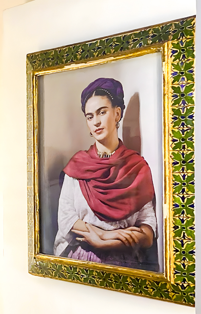Frida Kahlo portrait in ornate frame at Frida Kahlo Museum, Mexico City.