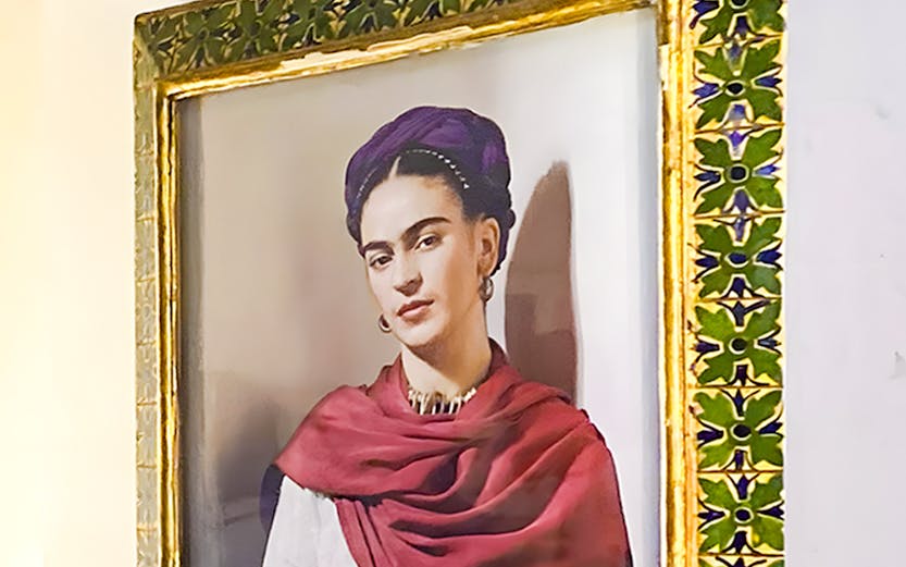 Frida Kahlo portrait in ornate frame at Frida Kahlo Museum, Mexico City.