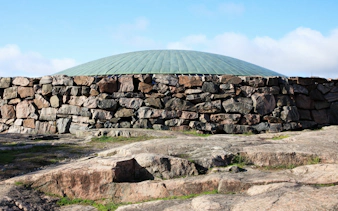 Rock church exterior with stone walls and dome in Helsinki, Finland.
