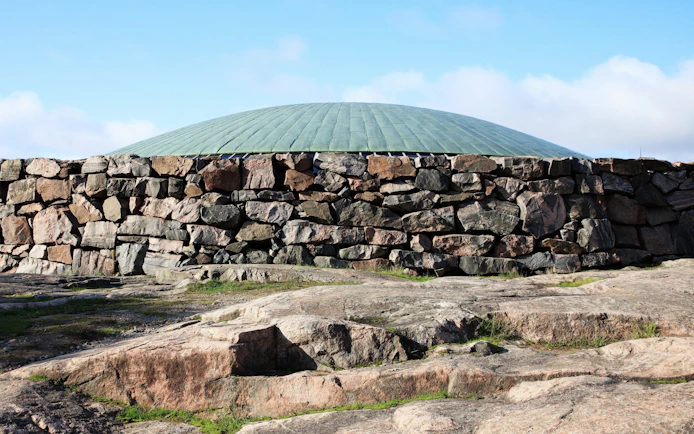 Rock church exterior with stone walls and dome in Helsinki, Finland.