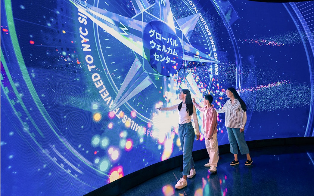 Visitors interacting with digital display at One World Observatory, New York City.