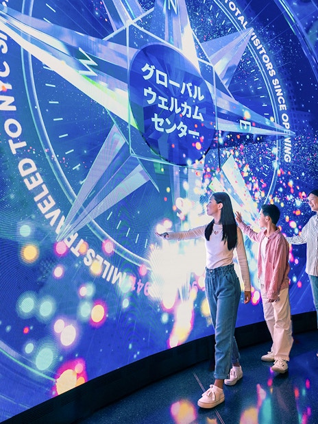 Visitors interacting with digital display at One World Observatory, New York City.