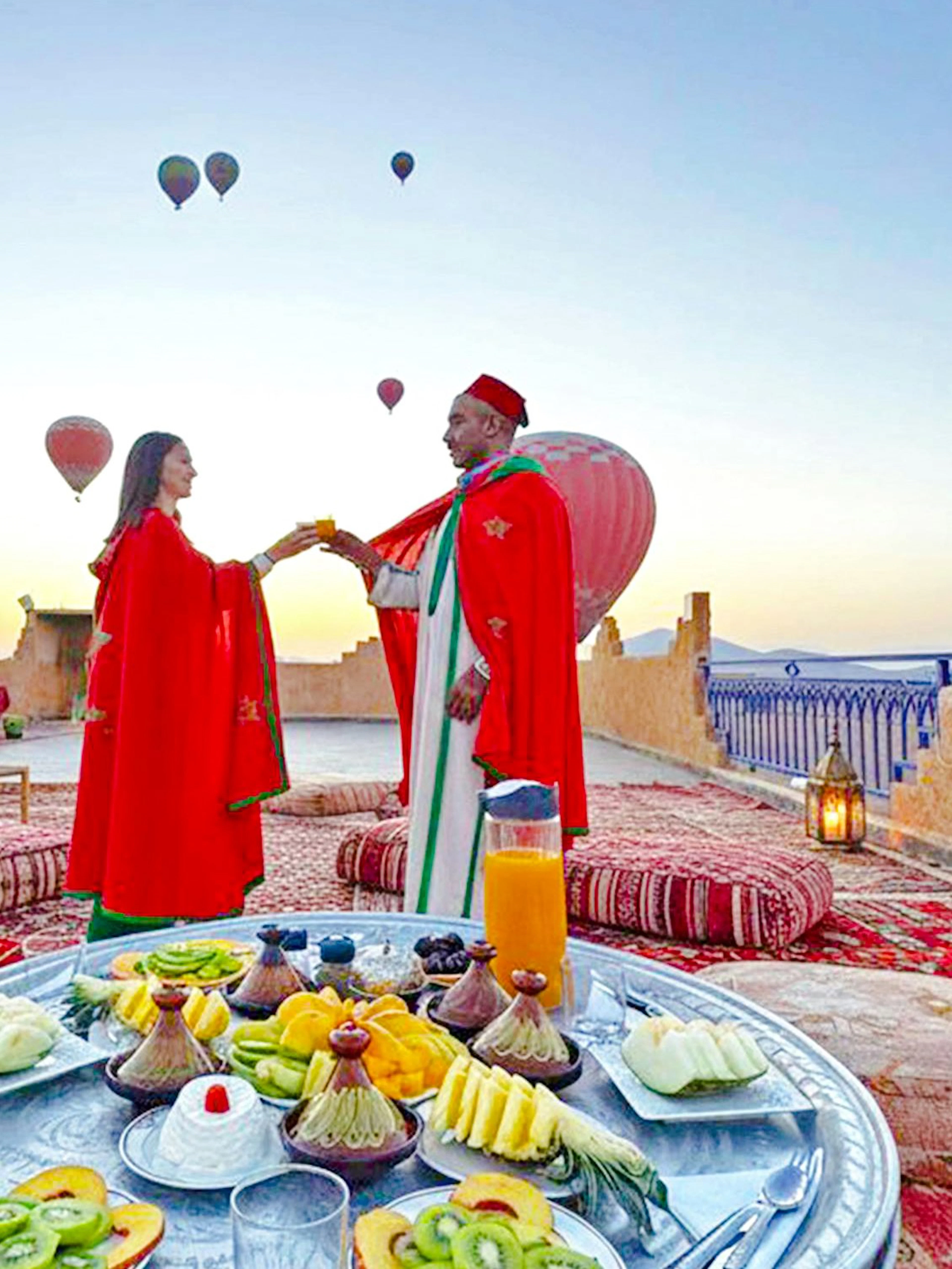 Lunch setup on a rooftop with hot air balloons in Marrakech.