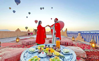 Lunch setup on a rooftop with hot air balloons in Marrakech.