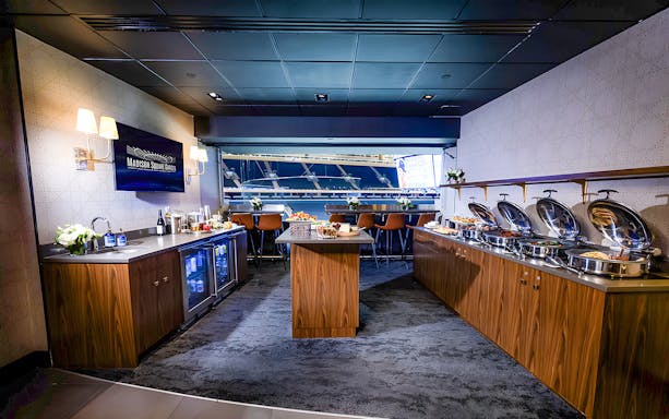 Madison Square Garden luxury suite with buffet and arena view.