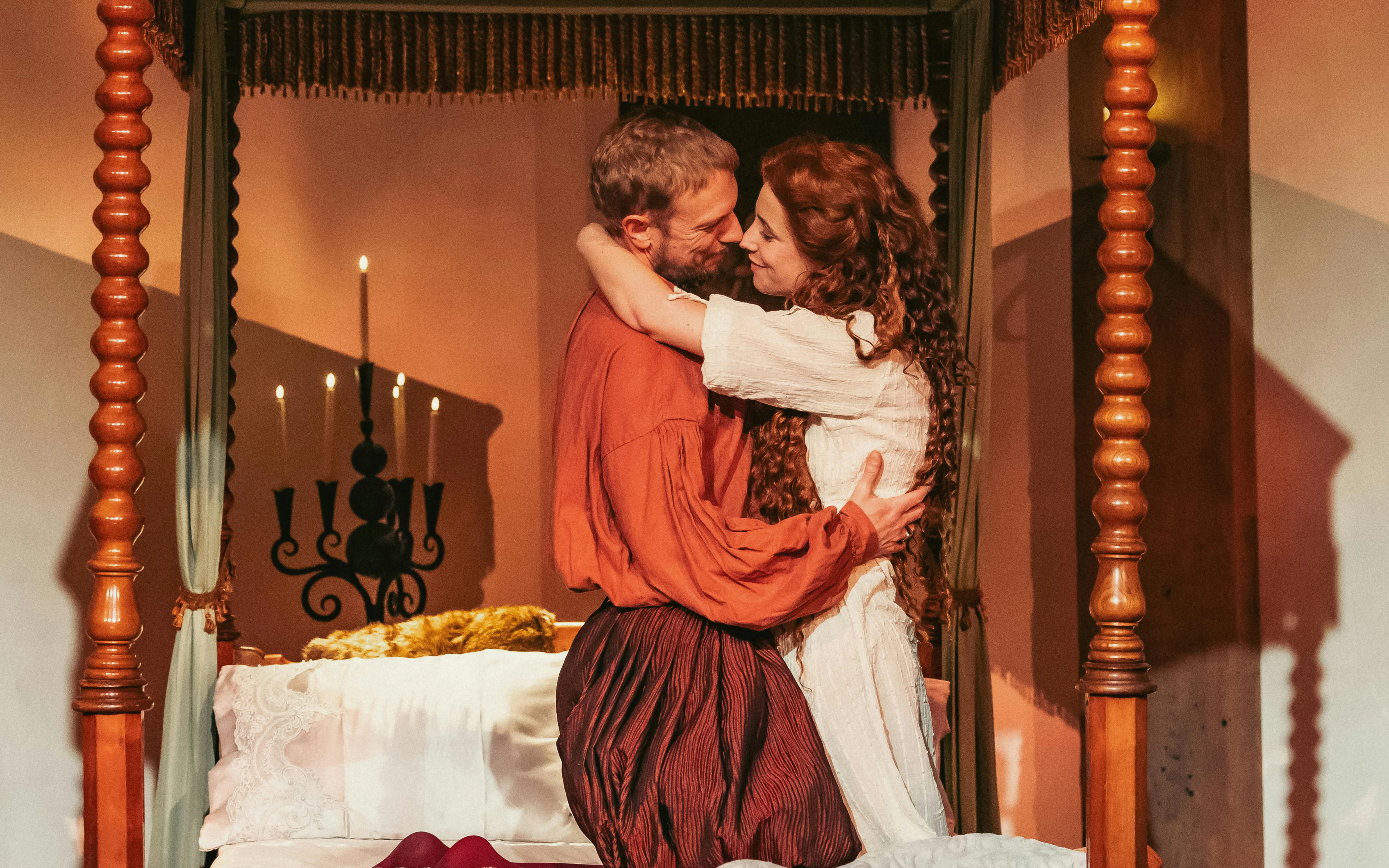Couple embracing in historical attire beside a candlelit bed, Willem van Oranje theme.