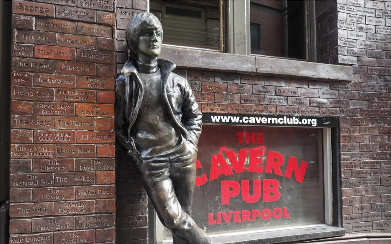 Statue outside The Cavern Club in Liverpool, featuring engraved bricks with band names.