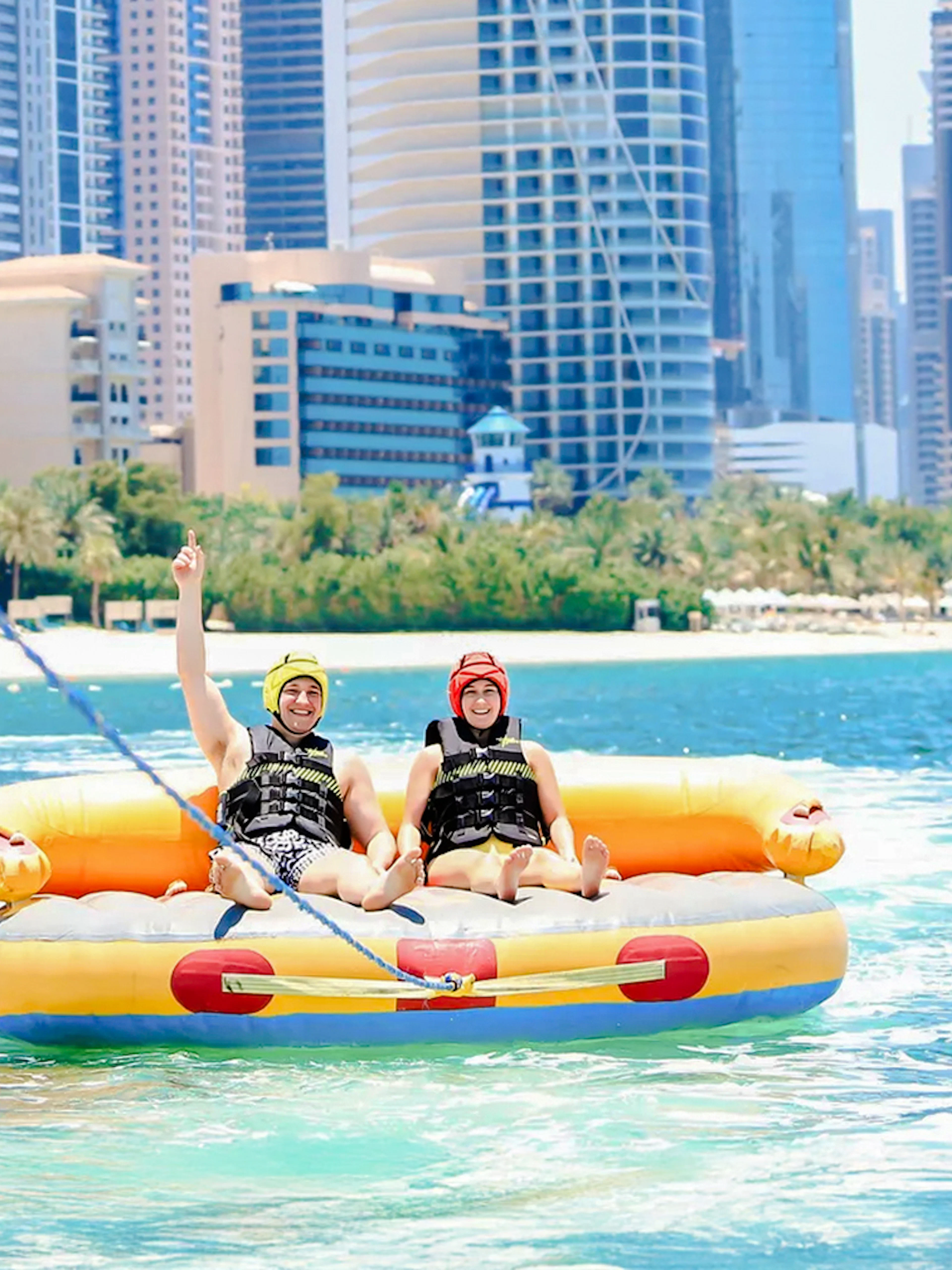 Men on a donut ride in Dubai with city skyline in the background.
