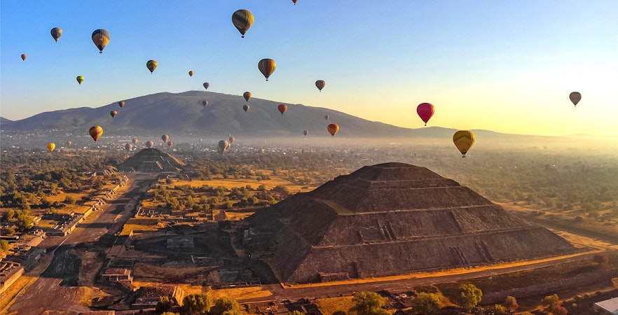 Hot air balloons floating above Teotihuacan pyramids, Mexico.