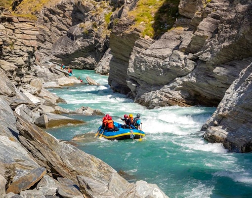 Whitewater rafting on Shotover River, Queenstown, navigating rocky canyon.
