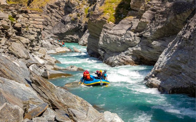 Whitewater rafting on Shotover River, Queenstown, navigating rocky canyon.