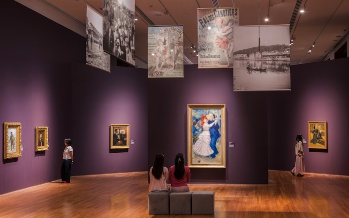 Impressionist paintings displayed in National Gallery Singapore with visitors observing art.