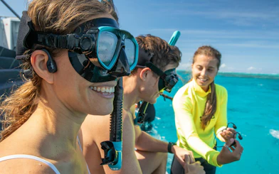 Snorkelers preparing for a half-day tour in Cairns, Australia, with clear blue ocean in the background.