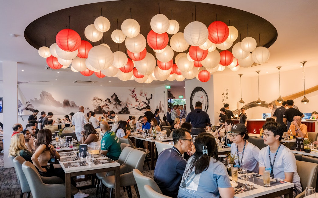Dining experience at a Michelin-starred restaurant with red and white lanterns and guests enjoying meals.