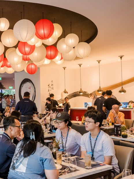 Dining experience at a Michelin-starred restaurant with red and white lanterns and guests enjoying meals.