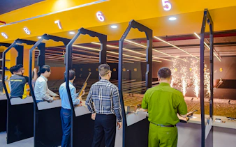 People participating in a shooting experience with instructors at an indoor range in Sa Pa.