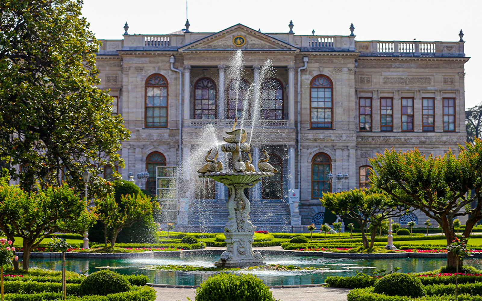Fountain in front of Dolmabahçe Palace, Istanbul, surrounded by gardens.