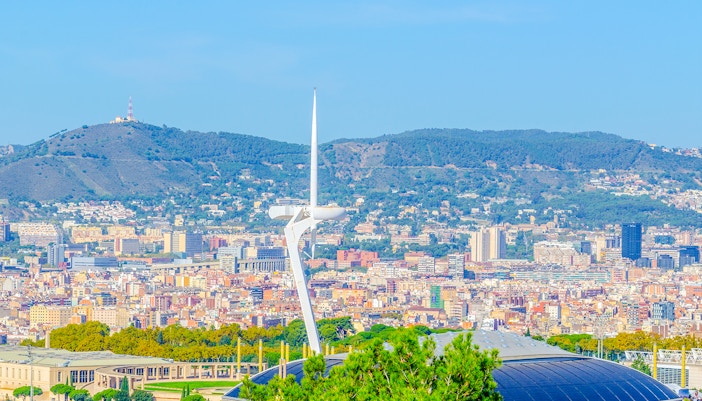 Torre de Calatrava in Montjuïc, Barcelona, with cityscape and hills in the background.