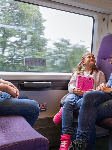 Family enjoying a ride on the Heathrow Express train to London Paddington.