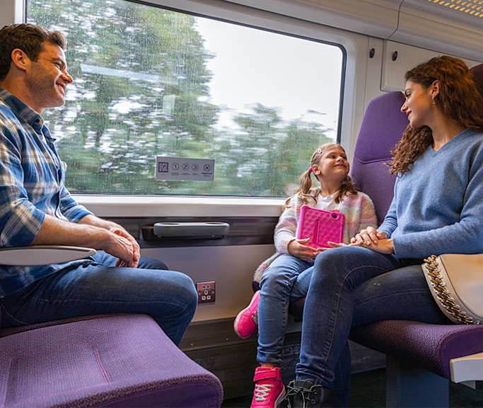 Family enjoying a ride on the Heathrow Express train to London Paddington.